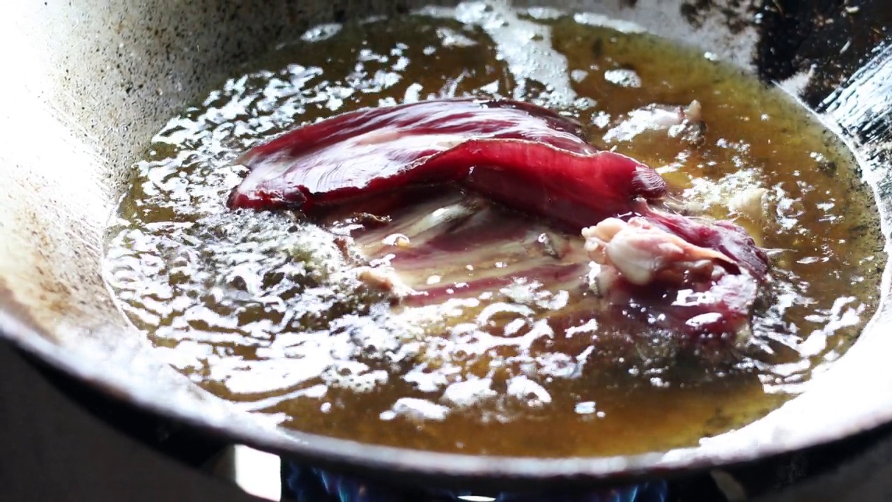 一个特写镜头是在一个旧平底锅里煎大块的牛肉。视频素材