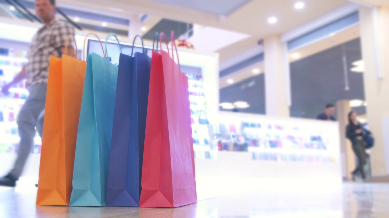彩色购物袋在商场的背景买家，时间流逝视频素材