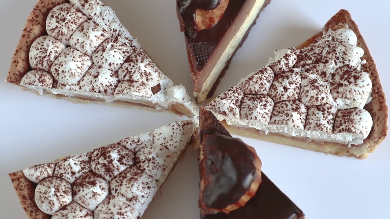 巧克力和奶油芝士蛋糕在桌子上旋转近景，俯视图。生日的概念视频下载