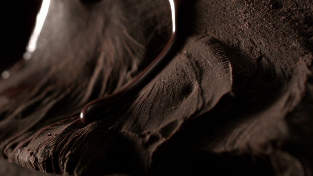 融化的巧克力流动在一堆牛奶纹理巧克力镜头宏观视频素材