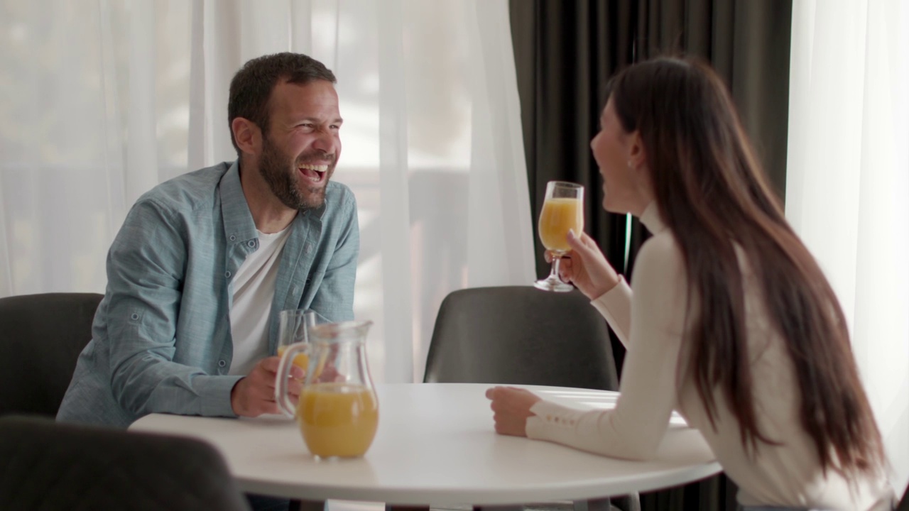 一对年轻夫妇在客厅喝橙汁视频下载