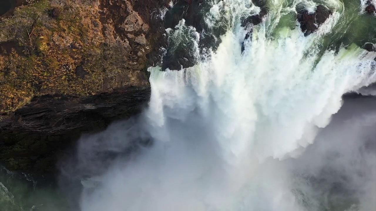 在赞比亚和津巴布韦之间的黄金时间里，维多利亚瀑布的无人机视图，粉红色的雾在发光视频素材