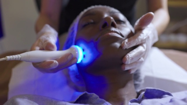 一名非裔美国妇女在水疗中心用超声波和光疗法对她的脸进行年轻化治疗视频下载