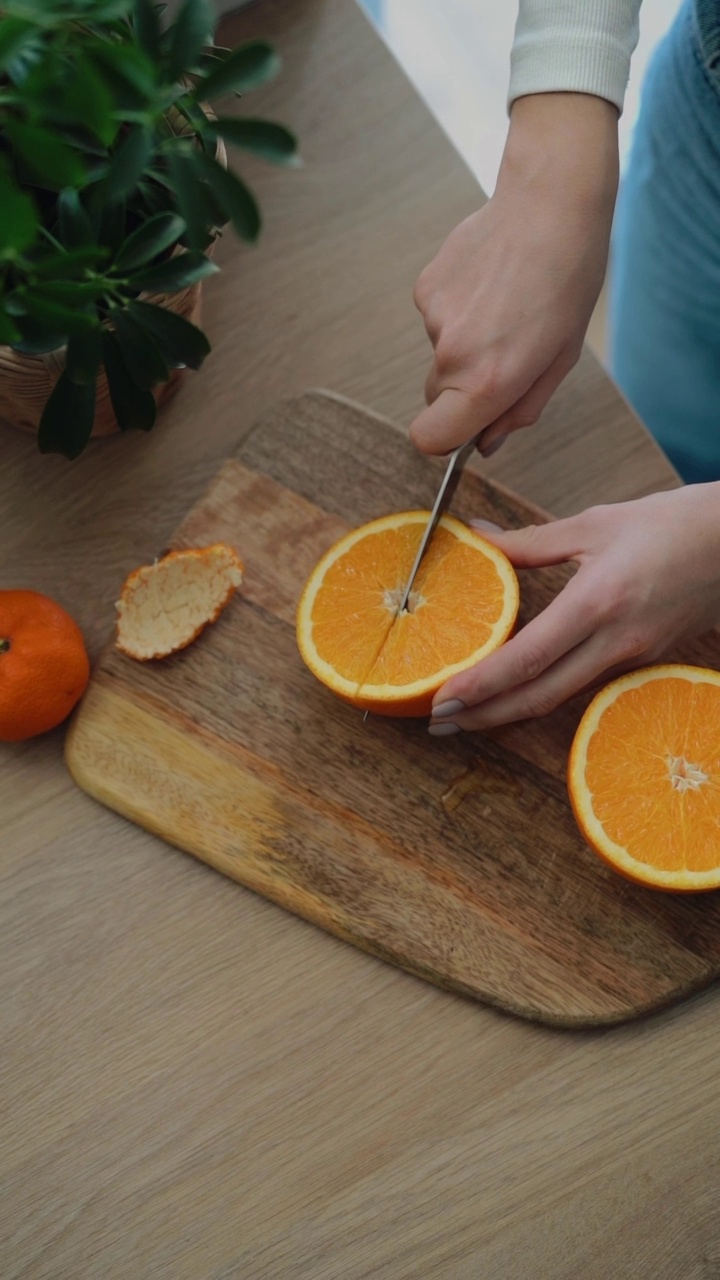 女人的手在木板上切橙子视频素材