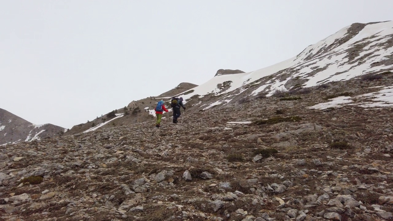成功的登山队在冬天走在落基山顶的山脊上视频下载