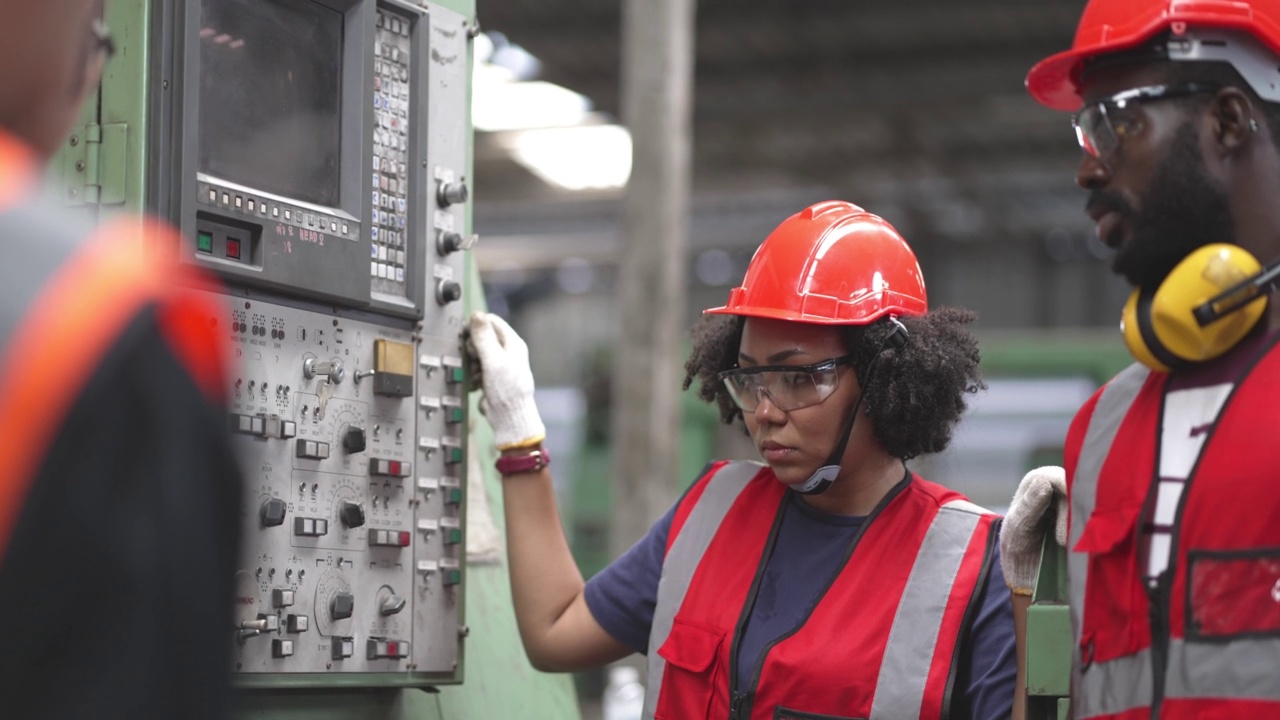 在工业建筑工地，身穿安全制服的非裔工人在机器运行前检查控制开关或维修。视频素材