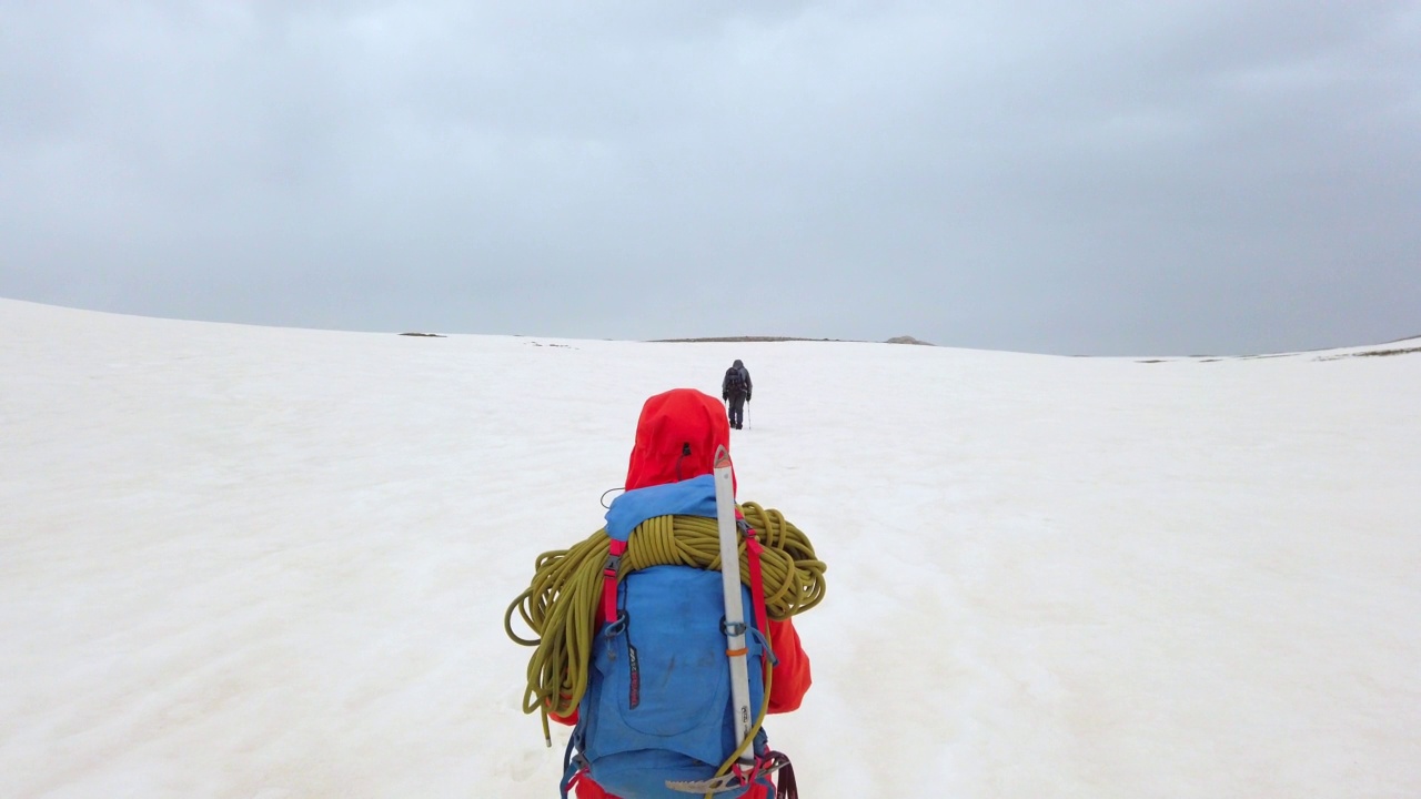成功的登山队在冬天走在高海拔雪山山顶的山脊上视频素材