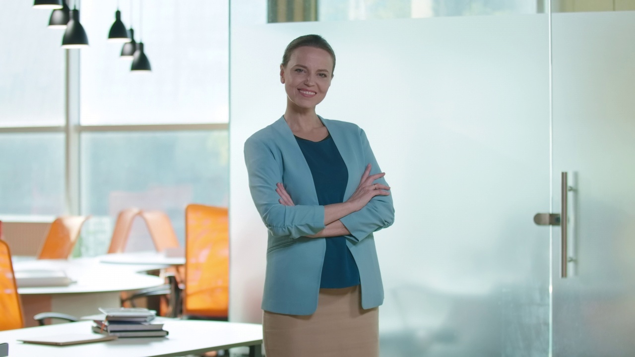 华丽自信的女性CEO交叉双手看着镜头微笑。聪明成功的白人女性在办公室室内摆姿势的肖像。生活方式和经营理念。视频素材