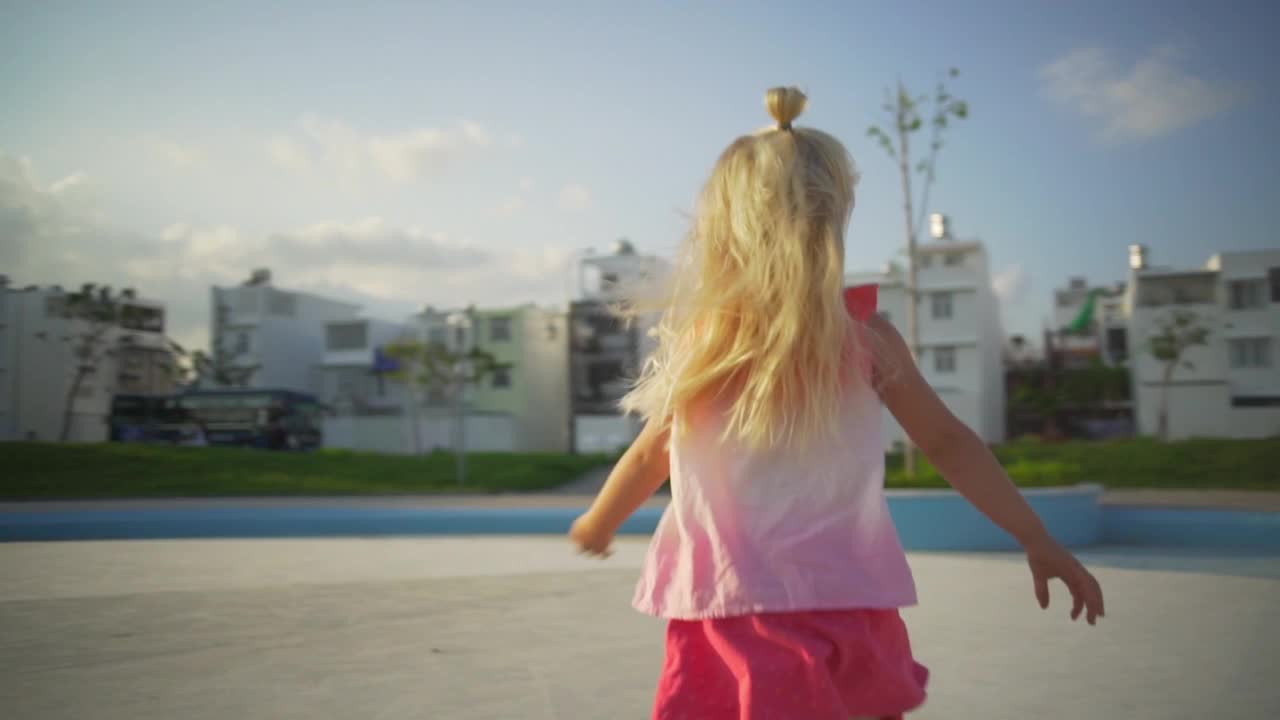 有趣的小女婴在操场上奔跑在日落时快速的慢动作视频素材