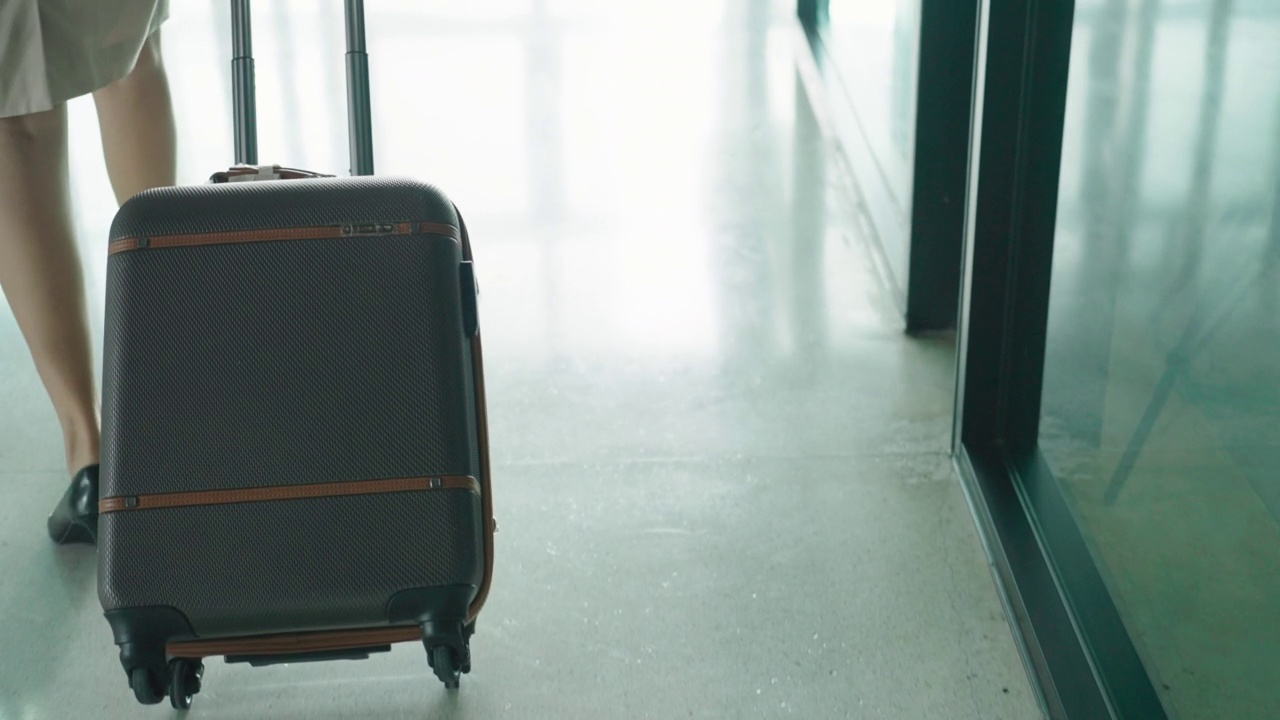 空乘拖着行李箱，走在旅客候机楼。视频素材