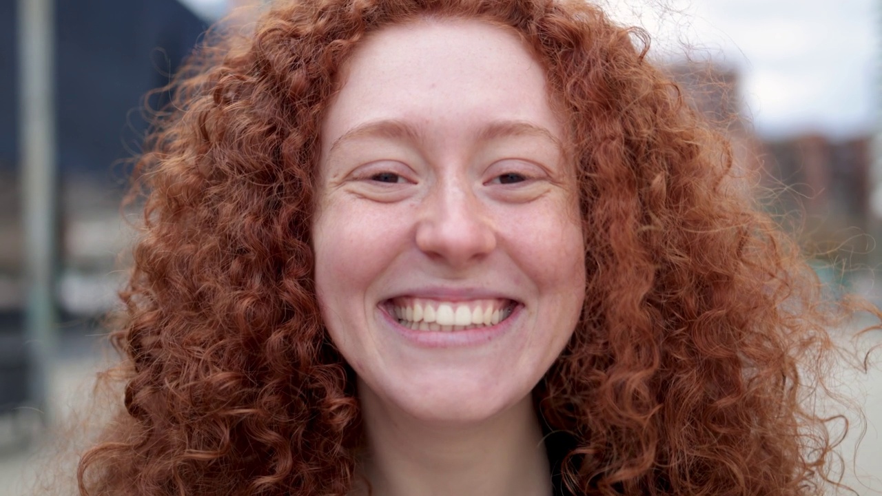 快乐的红发女孩微笑的相机户外-真实和真实的人的生活方式视频下载