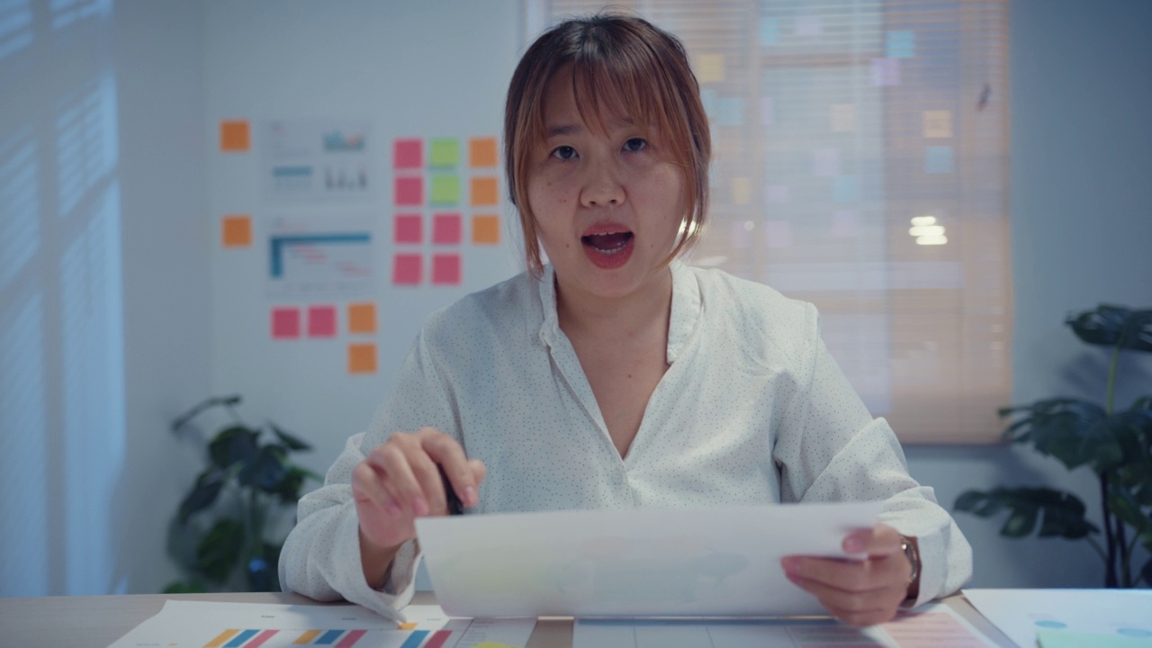 年轻的亚洲女商人使用笔记本电脑视频会议电话会议在会议室在晚上的办公室。视频素材
