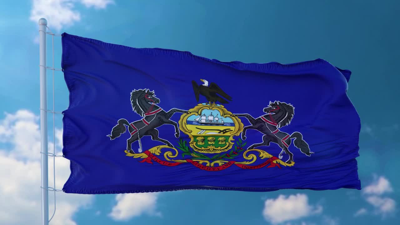 宾夕法尼亚州的旗帜在旗杆上迎风飘扬，蓝天为背景视频素材