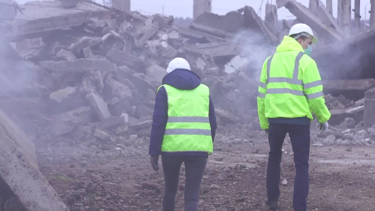 地震发生后，两名救援服务人员穿着绿色背心在废墟上发出信号慢莫视频下载