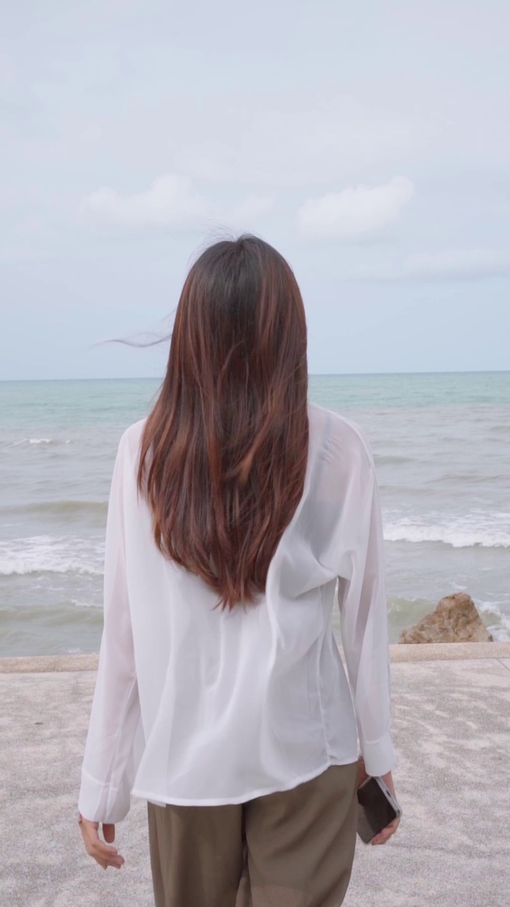 女人走向大海和大海的背景视频下载