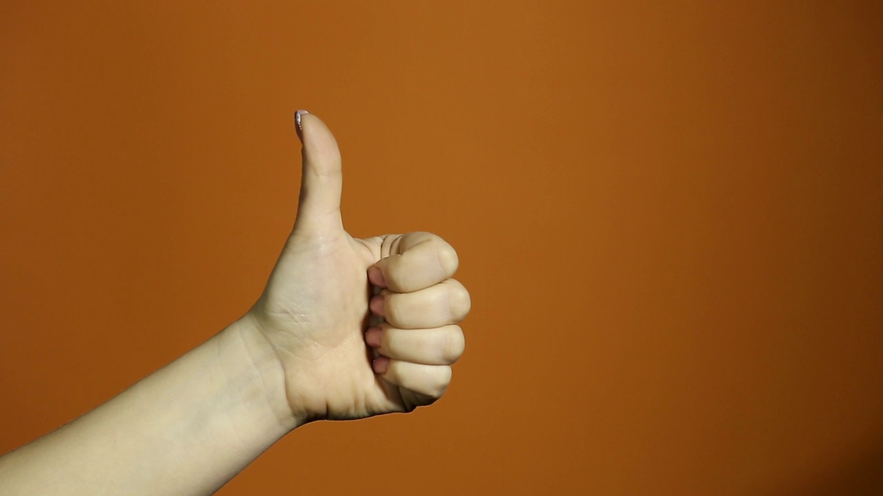 这个手势的概念是双手竖起大拇指，作为庆祝和祝贺获胜者的孤立在橙色背景上。视频下载