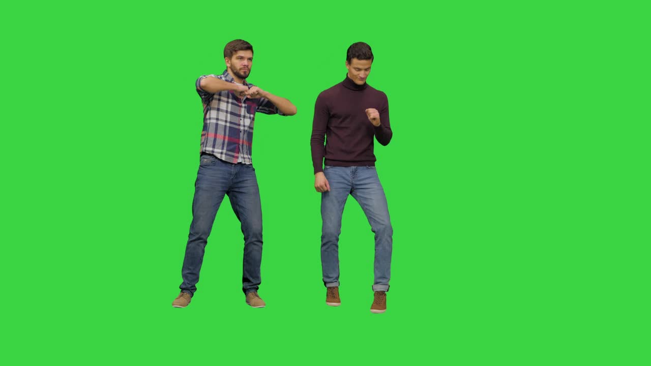 两个年轻人在绿色屏幕上以一种滑稽笨拙的方式跳舞，Chroma Key视频下载