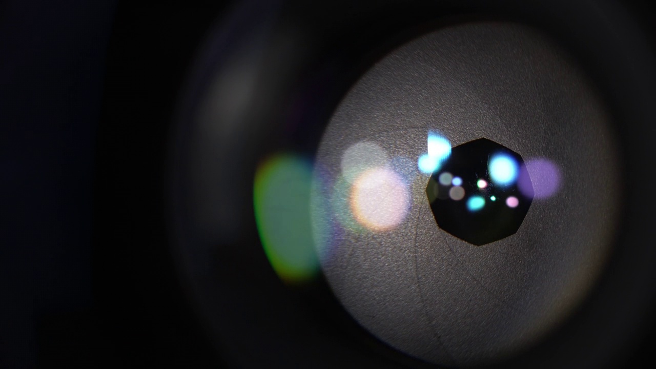 相机光学玻璃上的圆形彩色耀斑。开孔叶片的微距拍摄视频下载
