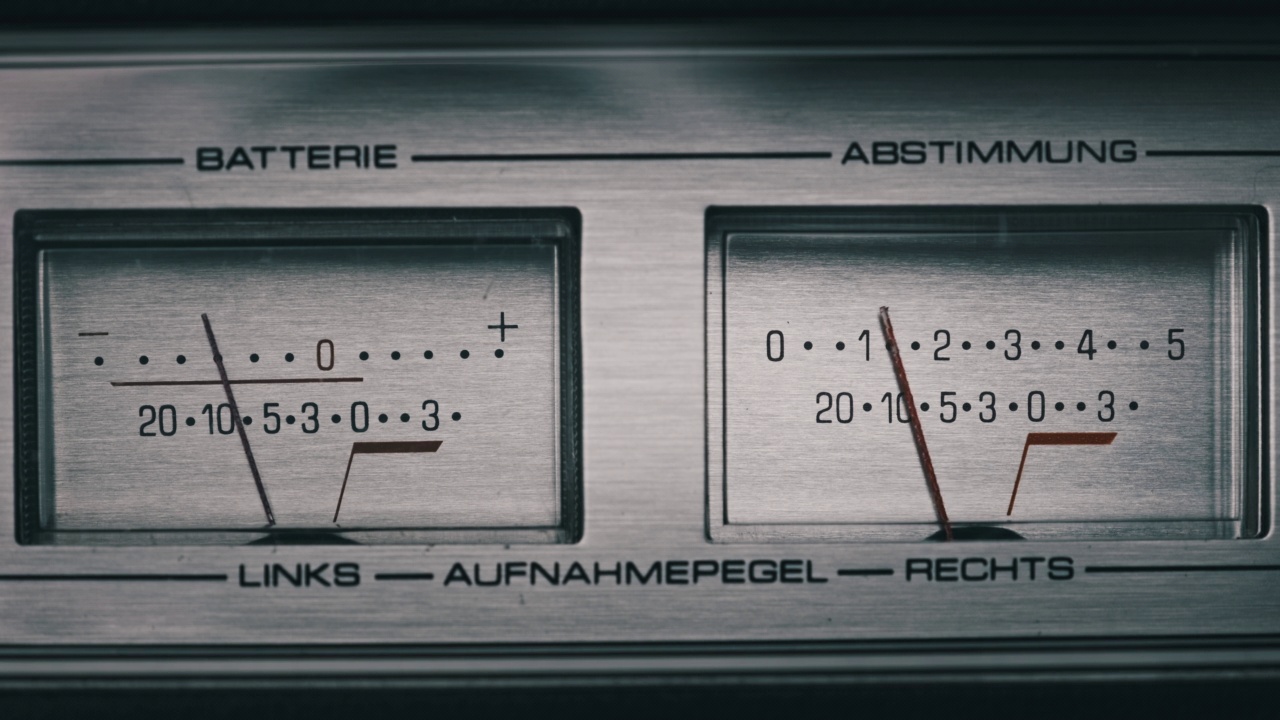 两个模拟VU仪表上的银色磁带录音机，箭头指示视频下载