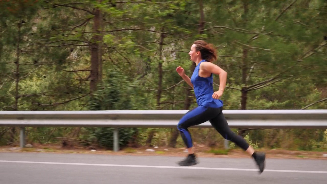 运行的概念。女运动员健身有氧运动。运动型女运动员在山路上快速奔跑，训练耐力跑。运动动机。艰苦的锻炼，健身活动视频下载