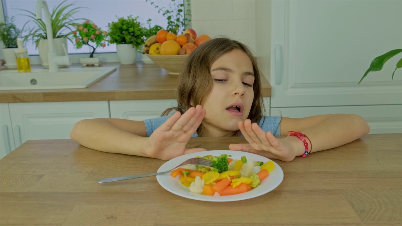 这孩子吃煮熟的蔬菜。有选择性的重点。食物。视频下载