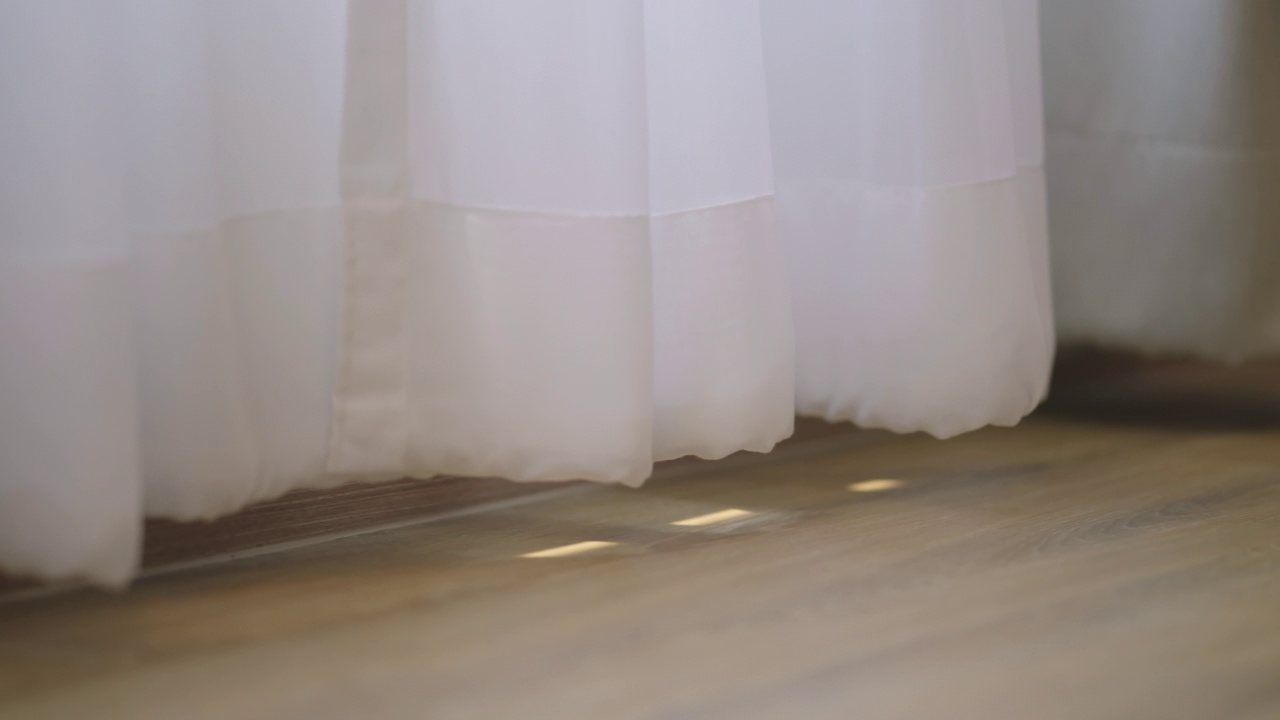 封闭式的白色透明窗帘与阳光结合，木地板上的阴影遮阳家居室内设计理念，舒适的家居晨光与阳光透过白色窗帘窗的宁静与蛤蜊时刻视频素材