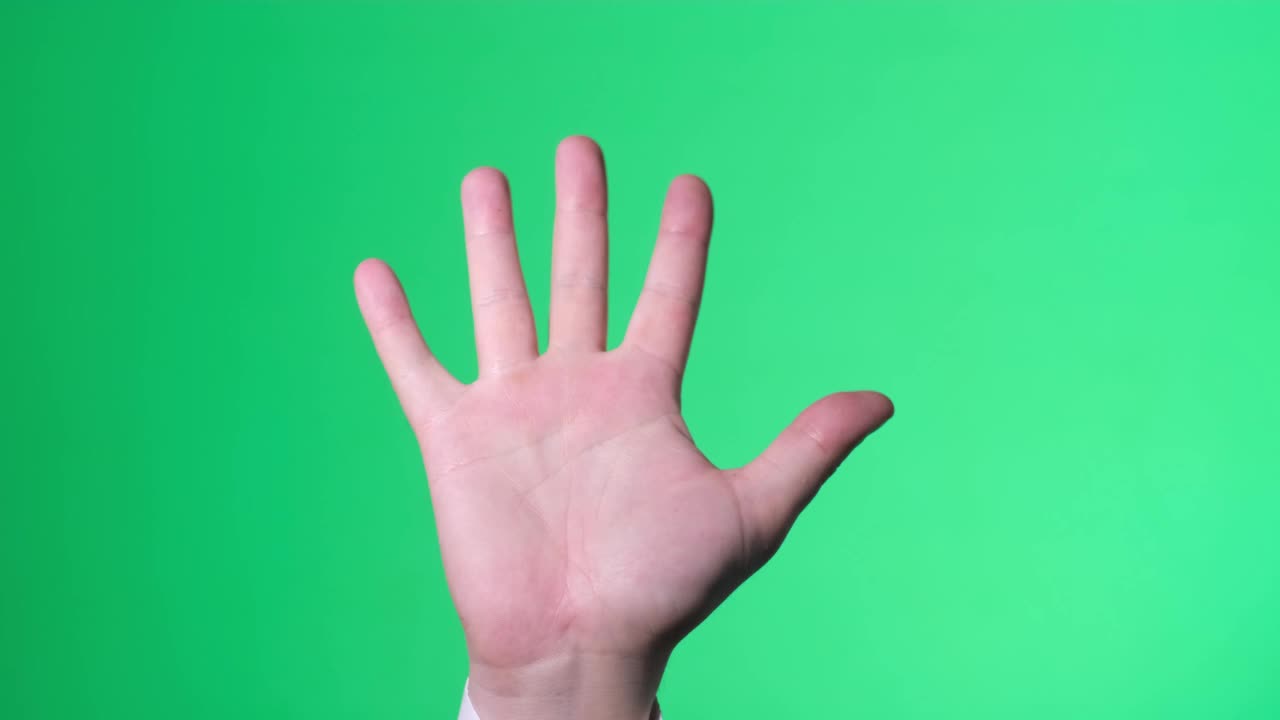 在一个绿色屏幕上张开的手打招呼。视频下载