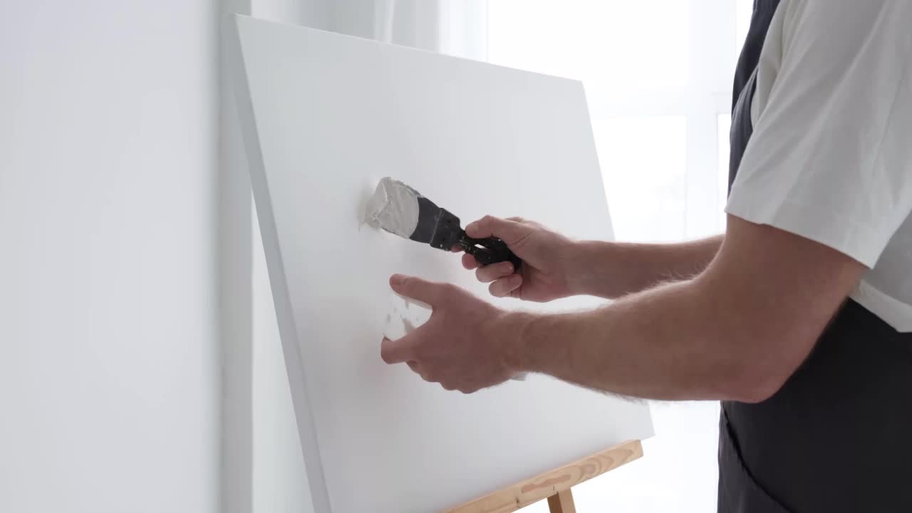 这位才华横溢的年轻艺术家在一块巨大的白色画布上作画，创作出了一幅色彩斑斓的油画视频下载