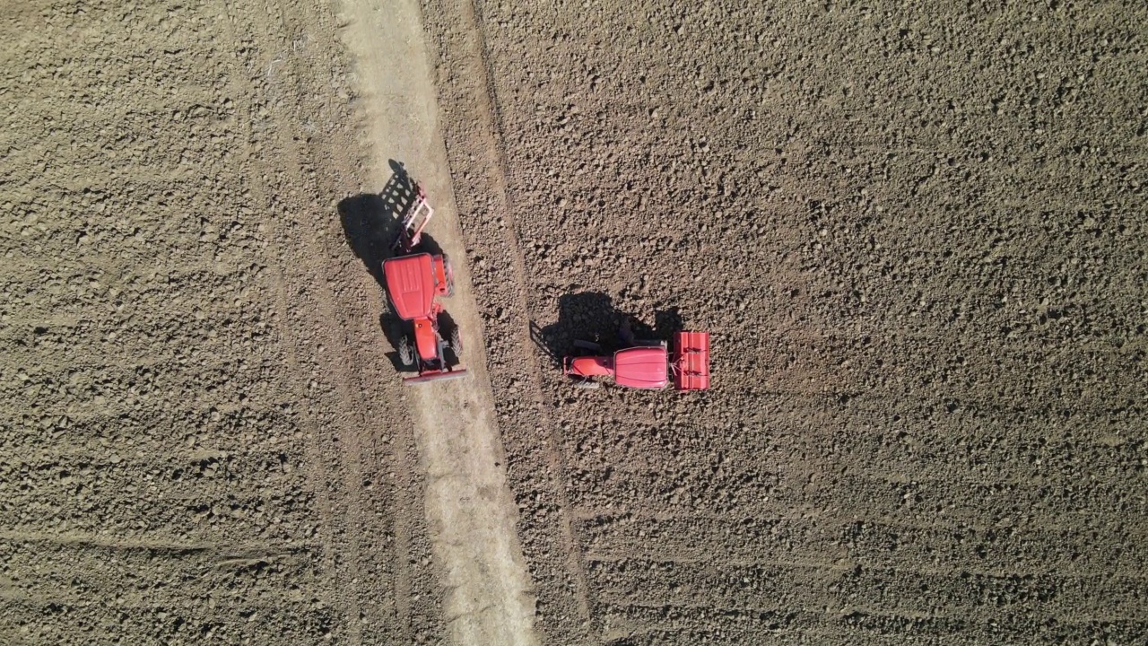 农民使用农业机械耕田的鸟瞰图。视频下载