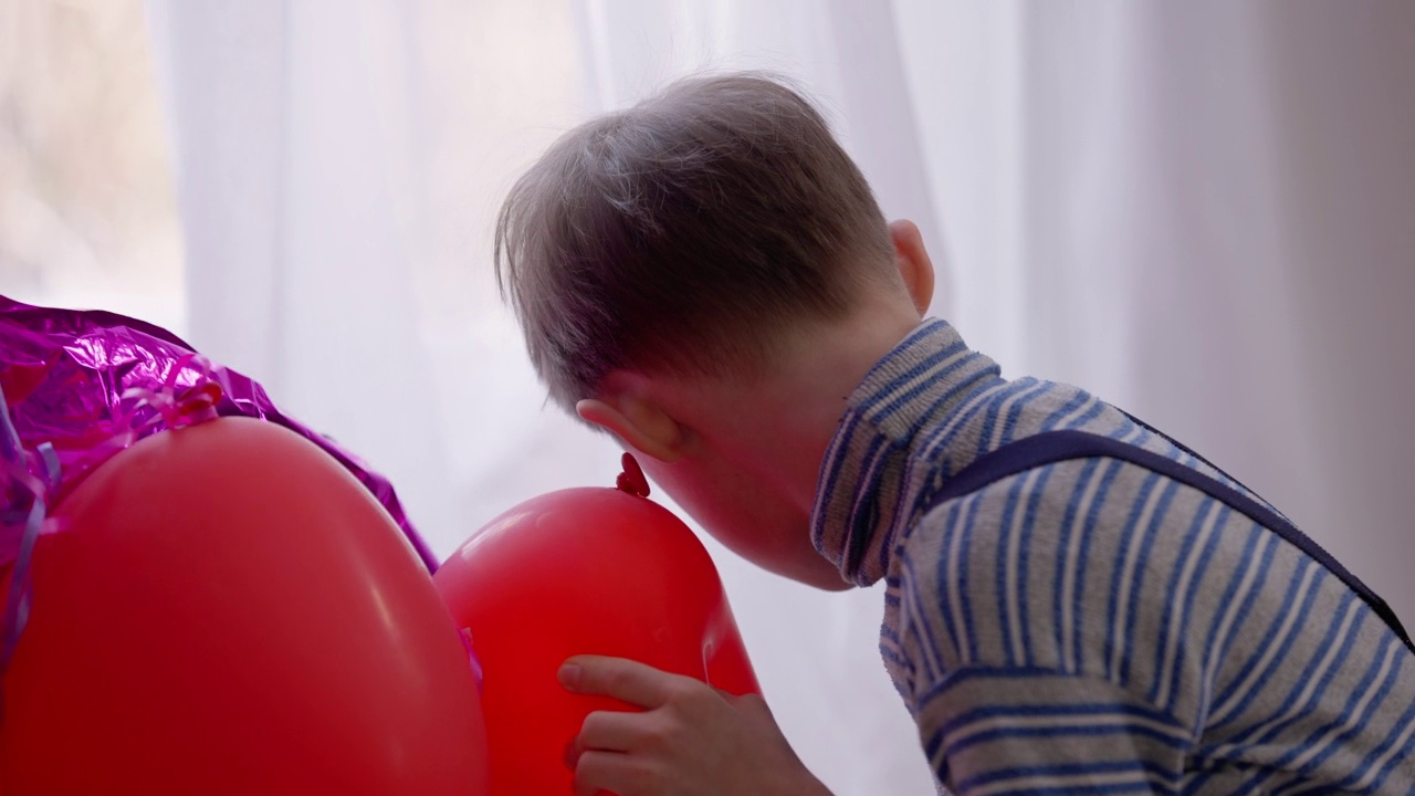 自闭症男孩在家听充气气球。古玩的侧面肖像可爱的白人儿童与精神障碍享受玩玩具。疾病和儿童概念。视频素材