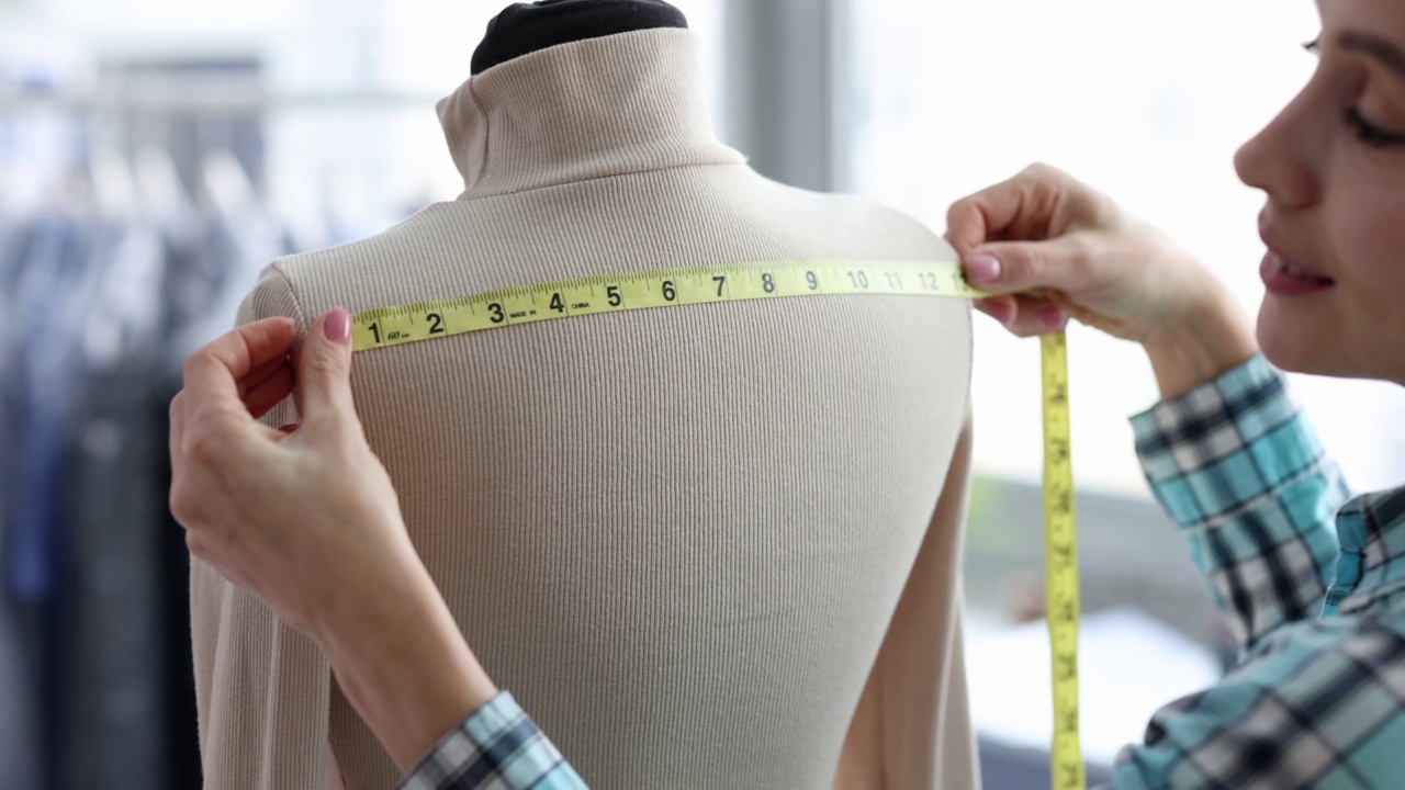 女裁缝在人体模型上测量衣服尺寸视频下载