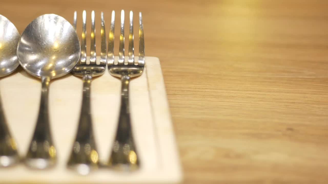 银餐具，叉子，刀和勺子放在桌子上视频素材
