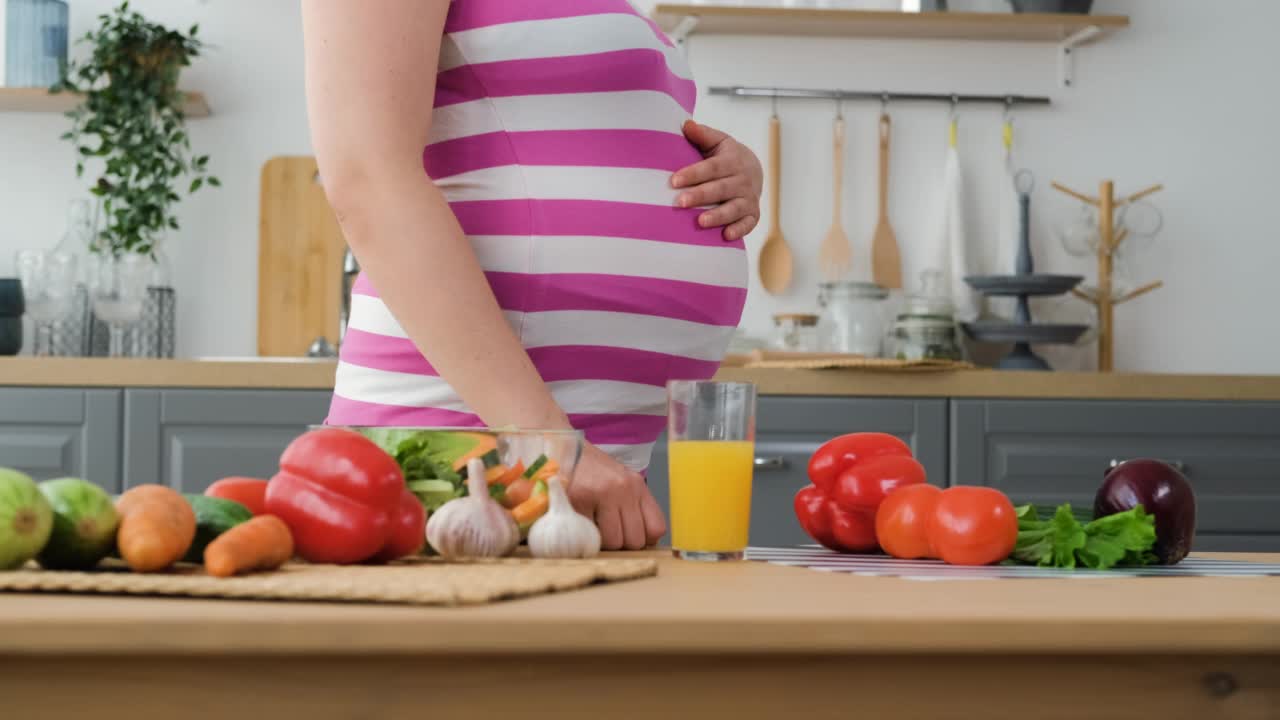孕妇在厨房喝橙汁视频素材