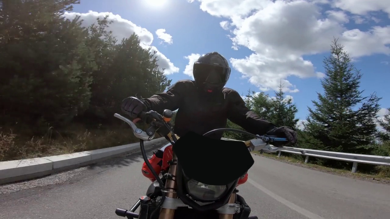 摩托车特技在弯曲的山路上快速行驶视频下载