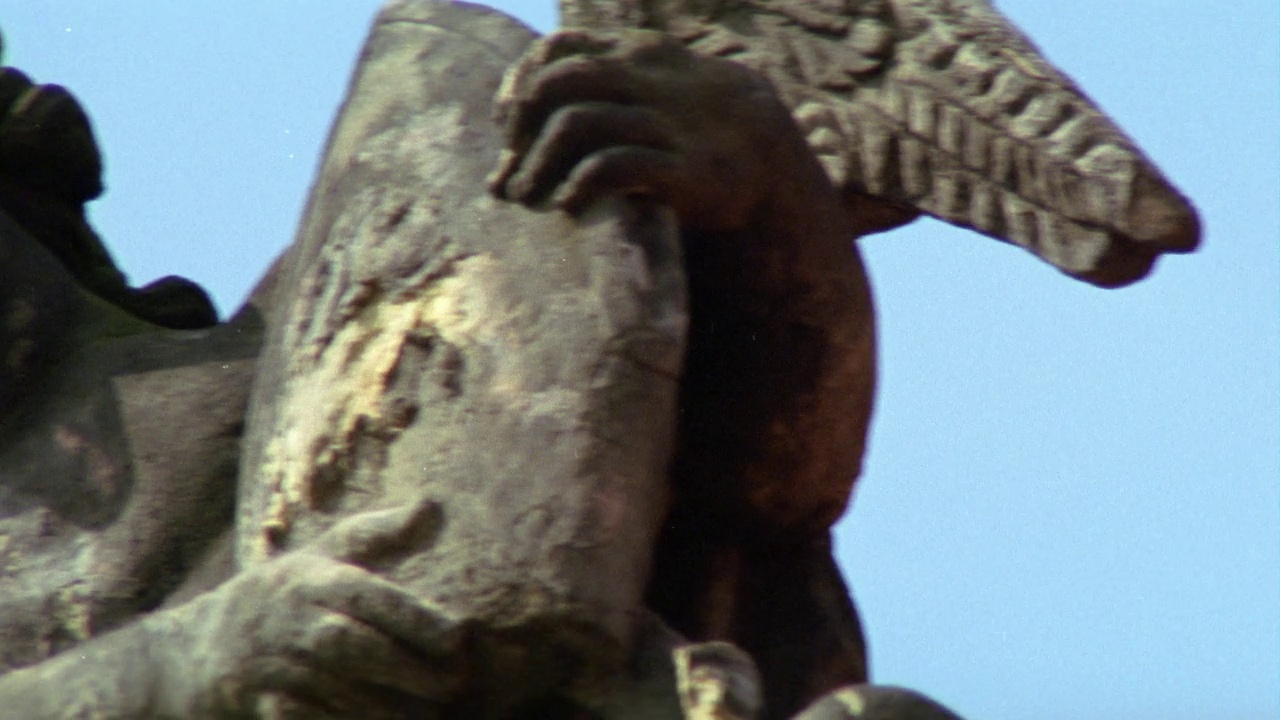从左到右的石像或雕塑的人举起三根手指在空中，其次是天使的翅膀的小天使雕像。可安装在建筑物的檐口或屋顶上。视频素材