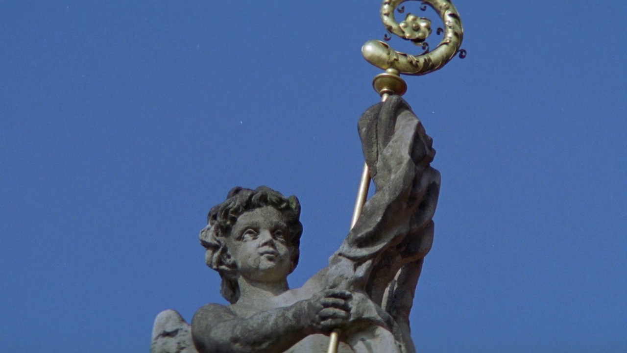 上角的石头小天使抱着金箍棒。雕像和雕塑。可以是檐口或建筑物的屋顶。放大脸部。视频素材