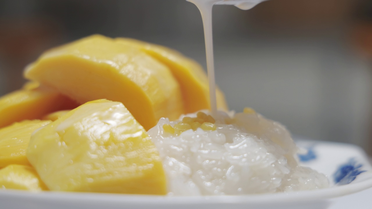 椰奶在芒果糯米上搅拌视频素材