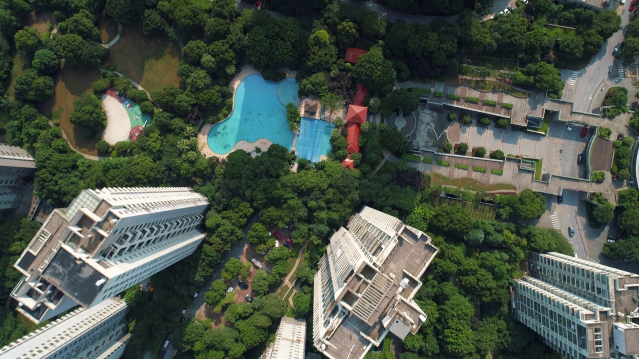无人机在一个阳光明媚的日子里在住宅楼上空拍摄。空中拍摄的中国社区公寓大楼。视频下载