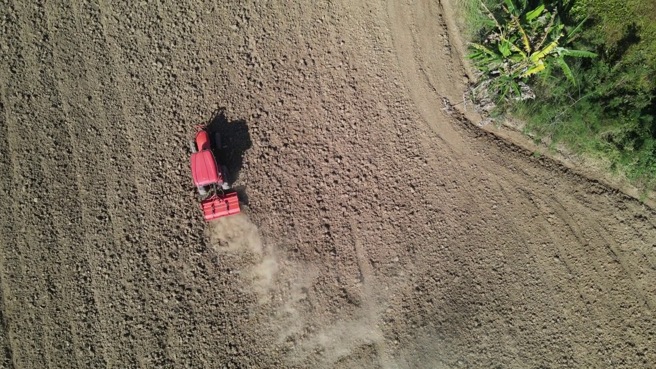 农民使用农业机械耕田的鸟瞰图。视频下载