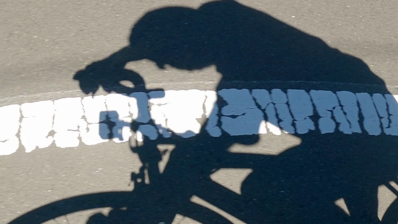 骑自行车的人骑自行车的影子向下移动视频素材