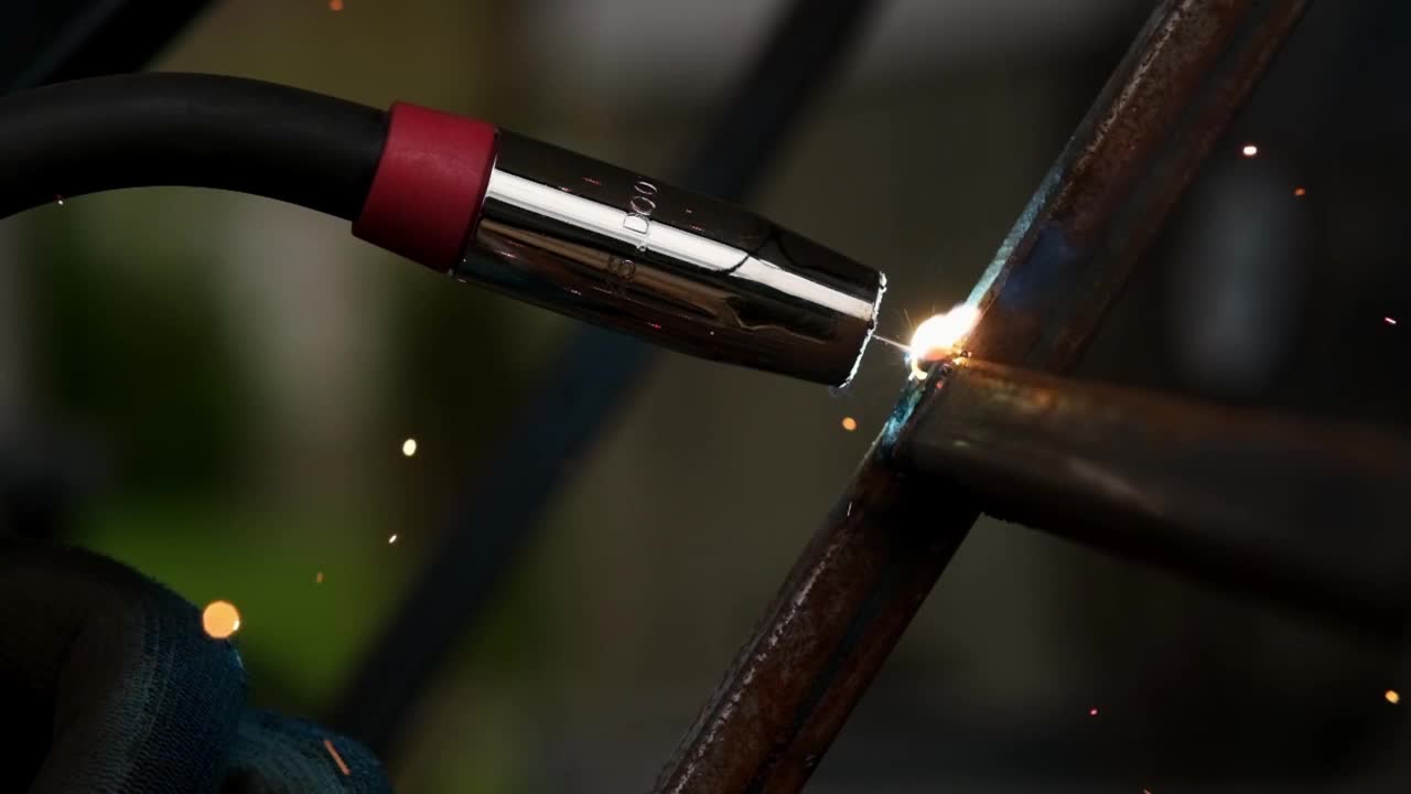 焊接火花，慢动作。一个工人在使用一台焊机。工作中的焊机的特写。工人焊接金属。视频下载