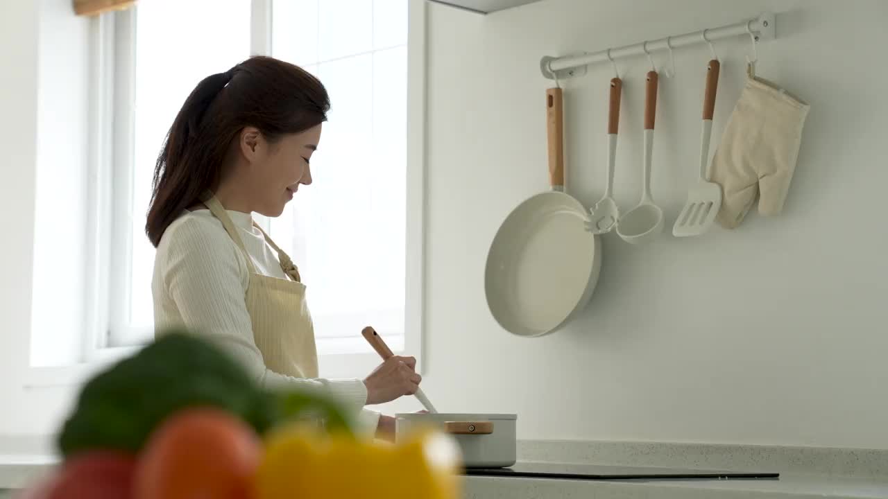房子，厨房-年轻女子做饭和微笑，韩国视频下载