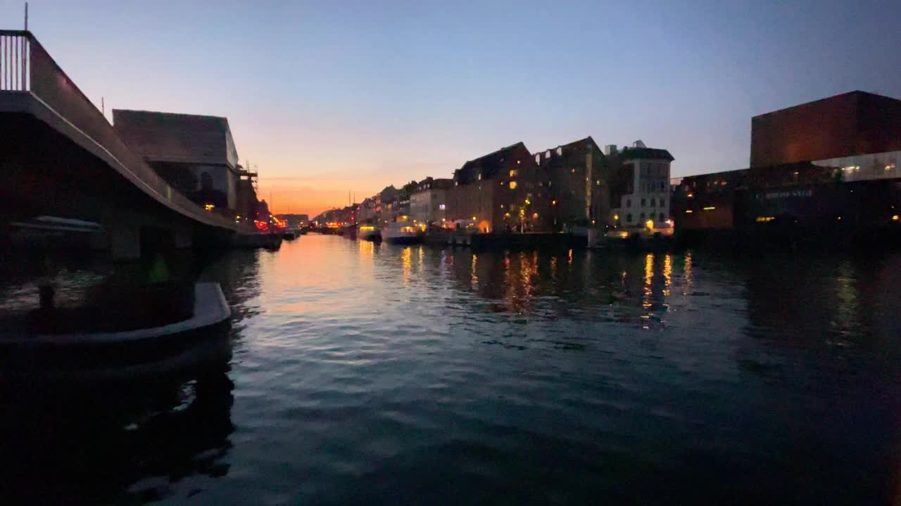从运河的水面看向夜晚的尼哈芬港。丹麦哥本哈根视频素材