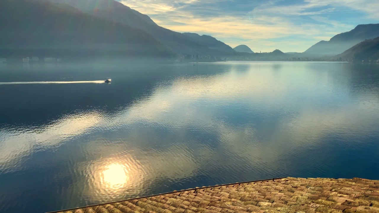 摩托艇在阿尔卑斯湖卢加诺与山和阳光视频素材