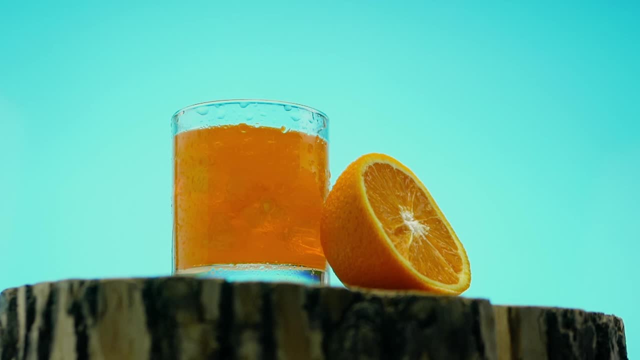 冰柠檬水，蓝色背景的黄色柠檬水。橙汁。软焦点视频素材