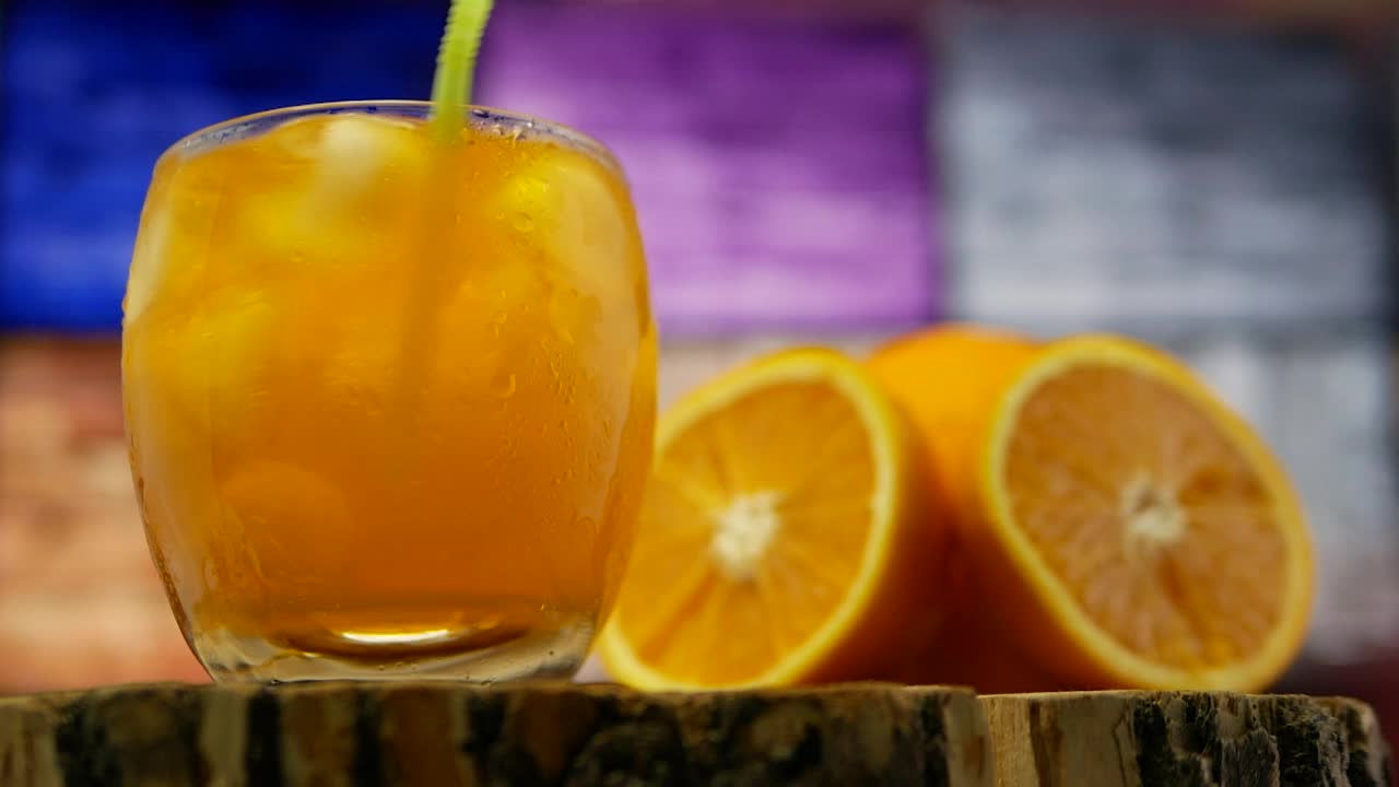 鸡尾酒在吧台上。冰鸡尾酒。透明玻璃杯里的黄色柠檬水。橙汁视频素材