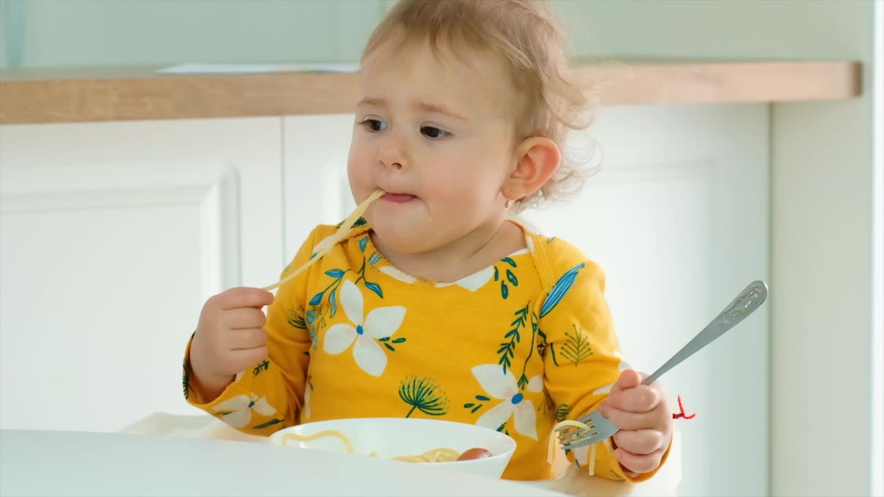 孩子在厨房里吃意大利面。有选择性的重点。食物。视频素材