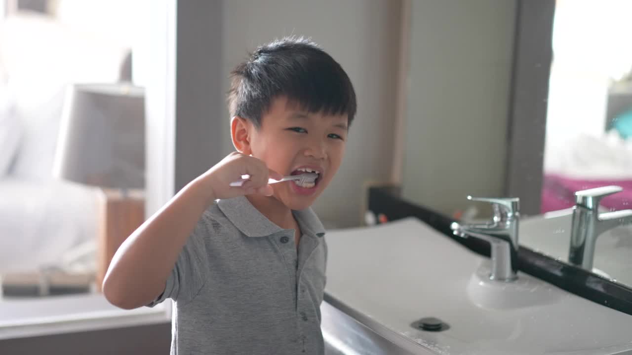 亚洲小孩在洁白干净的浴室里刷牙。日常健康和牙齿护理的概念视频下载