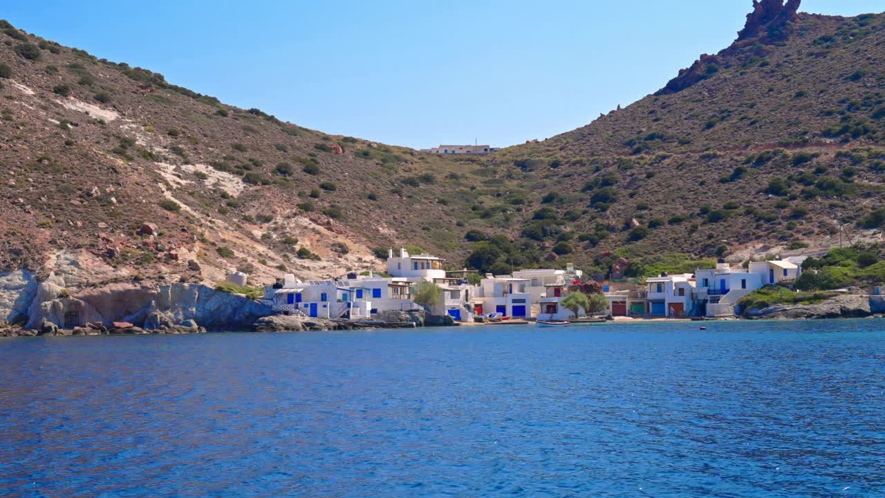希腊米洛斯岛，海岸线上一个偏僻的小渔村，有着蓝色门窗的白色建筑视频素材