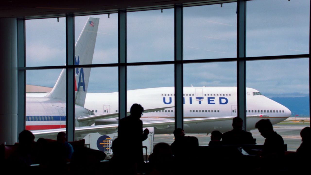 美国联合航空公司(United Airlines)波音747在加州旧金山(SFO / San Francisco)出租车上滑行时，一群微软人的剪影映在窗户上视频素材